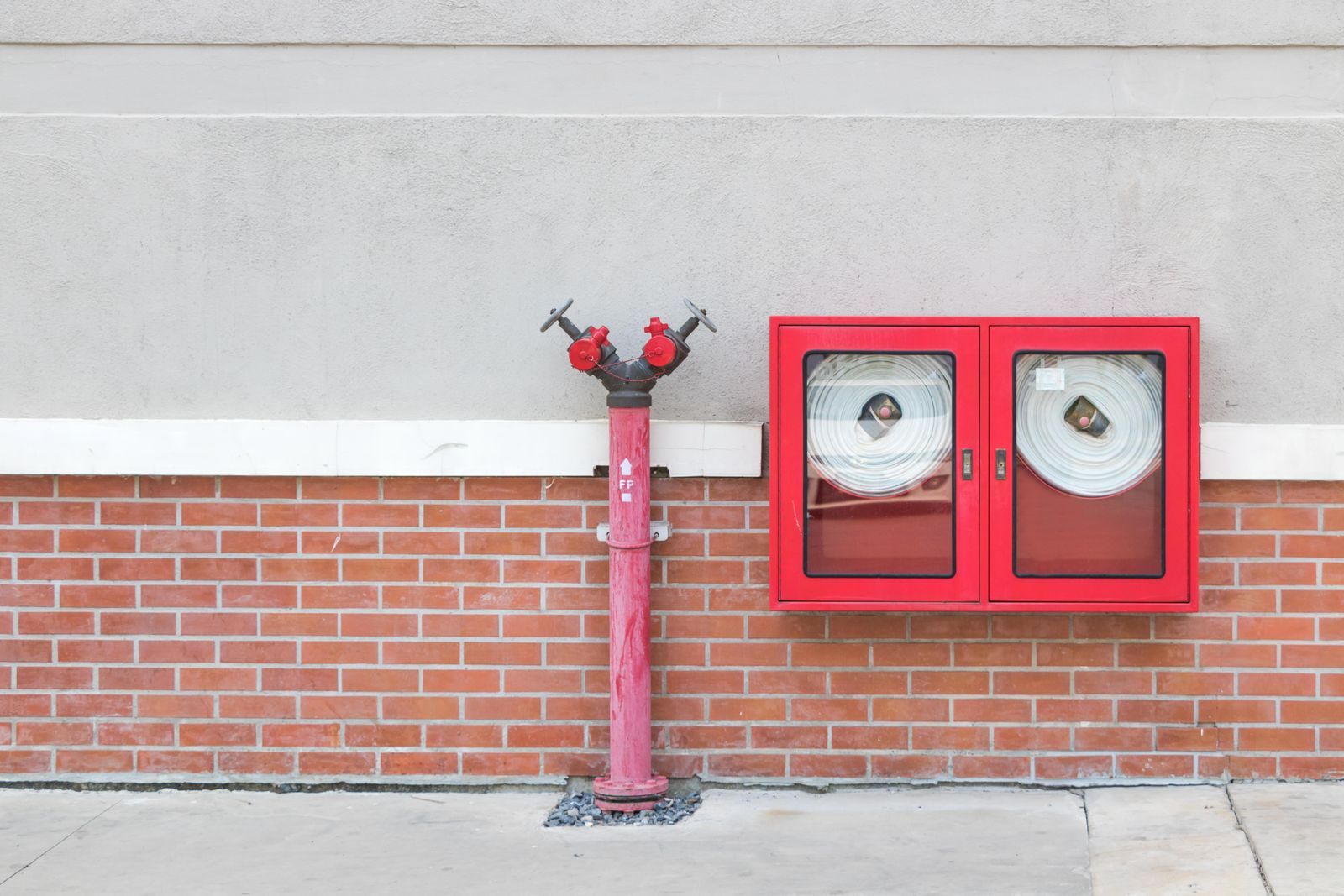 Fire hydrant and hose cabinets installed along a building exterior